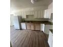 Functional kitchen with white cabinets, granite countertops, modern appliances and wood-look floors at 5128 Forrest Hills Ln, Las Vegas, NV 89108