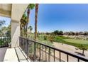 A covered balcony with wrought iron railings provides views of the golf course and palm trees at 52 Cascade Lake St, Las Vegas, NV 89148