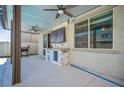 Outdoor patio area with a built-in bar, ceiling fans, and mounted television for entertaining guests at 5628 Ridgeland St, North Las Vegas, NV 89031