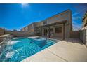 Inviting backyard pool with a waterfall feature, integrated jacuzzi, and covered patio with ceiling fans at 5628 Ridgeland St, North Las Vegas, NV 89031