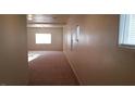 Hallway with neutral-colored walls and carpet, featuring multiple windows for natural light at 10371 Calypso Cave St, Las Vegas, NV 89141