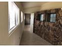 Hallway featuring stone accent wall, tiled floor, and view into another room at 1427 San Felipe Dr, Boulder City, NV 89005