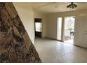 Open living area with tile flooring, stone accent wall, and access to outdoor space at 1427 San Felipe Dr, Boulder City, NV 89005