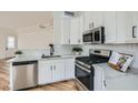 Modern kitchen features white cabinets, stainless steel appliances, and light wood flooring at 201 Kaelyn St # 4, Boulder City, NV 89005