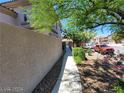 Paver pathway leading to a backyard featuring lush landscaping and glimpses of nearby homes at 206 Valerian St, Henderson, NV 89015