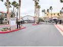 Gated community entrance with palm trees, red curbs, and asphalt drive at 2615 W Gary Ave # 1041, Las Vegas, NV 89123