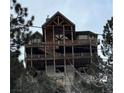 Multi-story log home with multiple decks and stunning views of the surrounding landscape at 311 Crestview Dr, Las Vegas, NV 89124