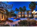 Inviting backyard pool with rock features, lush palms, and ambient lighting at 3235 S Tioga Way, Las Vegas, NV 89117