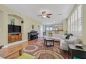 Cozy living room with wood floors, large windows, and a ceiling fan, seamlessly connecting to the kitchen and dining area at 337 Mattie Brook Ave, Henderson, NV 89015