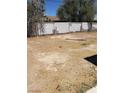 An exterior shot of a desolate backyard featuring a partial view of a wooden fence at 3601 Valley Forge Ave, Las Vegas, NV 89110