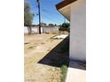 Partial view of a desolate backyard with a dirt patch and an adjoining building at 3601 Valley Forge Ave, Las Vegas, NV 89110