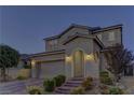 Inviting two-story home featuring a brick driveway, manicured bushes, and a two-car garage with beautiful exterior lighting at 426 Port Reggio St, Las Vegas, NV 89138