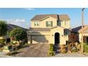 Charming two-story home featuring a brick driveway, a well-manicured lawn, and a two-car garage at 426 Port Reggio St, Las Vegas, NV 89138