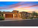 Single-story home with a beautiful desert landscape, two-car garage, and paver driveway at 50 Carolina Cherry Dr, Las Vegas, NV 89141