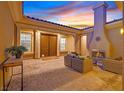 Outdoor patio with a fireplace, tiled flooring, outdoor furniture, and an arched doorway at 50 Carolina Cherry Dr, Las Vegas, NV 89141