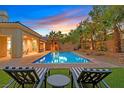 Sparkling pool with lush landscaping, lounge chairs, and an outdoor seating area at 50 Carolina Cherry Dr, Las Vegas, NV 89141
