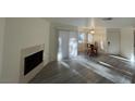 Open concept living room featuring fireplace, sliding door, and dining area with natural light at 5044 S Rainbow Blvd # 106, Las Vegas, NV 89118