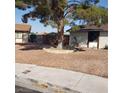 An image of the front yard with a single tree in a decorative rock border at 5284 Wellesley Ave, Las Vegas, NV 89122