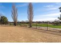 Spacious backyard with desert landscaping and wrought iron fence overlooking a golf course at 5467 Eleganza Ave, Pahrump, NV 89061