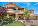 Inviting two-story home featuring a balcony, three-car garage, and a lush lawn at 5872 Revital Ct, Las Vegas, NV 89131