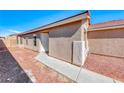 Side view of single story home with white door and desert landscaping at 6552 Coldwater Bay Dr, Las Vegas, NV 89122