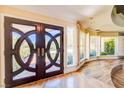 Inviting foyer showcasing elegant double doors, hardwood floors, and natural light at 6980 Mira Vista St, Las Vegas, NV 89120