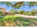 Expansive front yard with mature trees and lush landscaping, creating a serene setting at 6980 Mira Vista St, Las Vegas, NV 89120