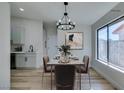 This dining room is virtually staged and includes a chandelier and many windows at 7437 Lattimore Dr, Las Vegas, NV 89128