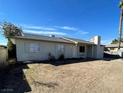 A house featuring a low-pitched roof, small windows, and stucco chimney at 834 Benita Pl, Boulder City, NV 89005