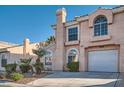 Two-story home featuring stucco siding, attached garage, and desert-style landscaping at 8425 Sewards Bluff Ave, Las Vegas, NV 89129