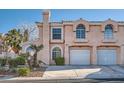 Two-story home with attached garage, stucco siding, arched windows and well-maintained landscaping at 8425 Sewards Bluff Ave, Las Vegas, NV 89129