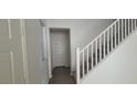 Clean entryway featuring gray floors, white walls, and white staircase to upper level at 8695 Canfield Canyon Ave, Las Vegas, NV 89178