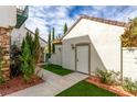 Side yard featuring desert landscaping, a white door, and an ornate metal gate at 916 Granger Farm Way, Las Vegas, NV 89145
