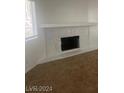 Bright living room with a decorative fireplace and plush carpeting at 924 Falconhead Ln # 102, Las Vegas, NV 89128