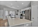 Bright kitchen featuring an island with white cabinets, stainless steel appliances, and wood flooring at 1104 Christopher View Ave, North Las Vegas, NV 89032
