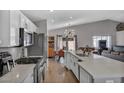 Bright kitchen features an island with white cabinets, stainless steel appliances, and wood flooring at 1104 Christopher View Ave, North Las Vegas, NV 89032