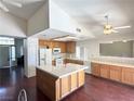 Open kitchen features light wood cabinets, tile countertops, an island, white appliances and hardwood flooring at 1301 Misty View Ct, North Las Vegas, NV 89031