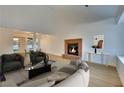 Staged living room featuring hardwood floors, brick fireplace, and neutral-toned furniture at 163 Spinnaker Dr, Henderson, NV 89015