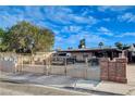 Modest single story home with an expansive gated front yard and covered parking area at 1808 Walnut Ave, Las Vegas, NV 89101