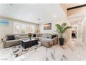 Inviting living room featuring a large gray sectional, marble floors, and natural light at 1920 Parkchester Dr, Las Vegas, NV 89108