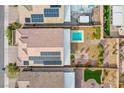 Aerial view of a home with a pool, patio with firepit, solar panels and landscaped backyard at 324 S Lisbon St, Henderson, NV 89015