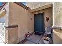 Inviting entrance with a teal front door, decorative plants, and a small seating area at 3335 Wasatch Cedars St, Las Vegas, NV 89122
