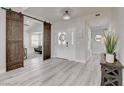 Inviting foyer with wood-look flooring, barn door and an elegant front door with decorative glass panels at 5429 Painted Sunrise Dr, Las Vegas, NV 89149