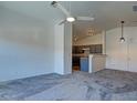 Open-concept living room leads to a kitchen, with grey carpet and abundant lighting at 5457 Jackpot Winner Ln # 101, Las Vegas, NV 89122