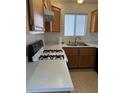 Traditional kitchen with a white countertops, oak cabinets, and a gas range cooktop at 5564 Ness Ave, Las Vegas, NV 89118