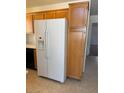 Bright kitchen featuring a large, white refrigerator and light wood cabinets at 5564 Ness Ave, Las Vegas, NV 89118