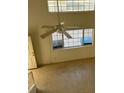 Open living room showing a ceiling fan and large windows allowing ample natural light at 5564 Ness Ave, Las Vegas, NV 89118