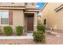 Close up of the front door with small, well-manicured bushes surrounding the walkway at 5967 Grechetto Ct, Las Vegas, NV 89141