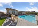 Enjoy the backyard pool and patio area with comfortable seating, perfect for outdoor entertaining and relaxation at 6192 Lautman Ridge Ct, Las Vegas, NV 89141