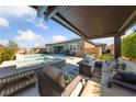 Inviting outdoor living space featuring a cozy seating area, stylish furnishings, and a sparkling pool nearby at 6192 Lautman Ridge Ct, Las Vegas, NV 89141